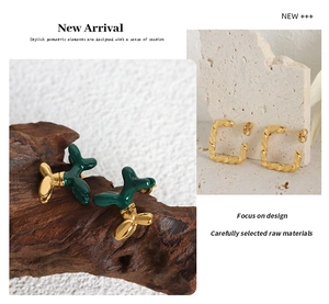Detail of green enamel balloon dog stud and hammered gold-plated geometric earrings