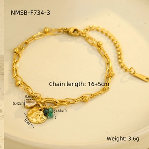 Detailed close-up of gold titanium bracelet with teardrop zircon and round tag pendant