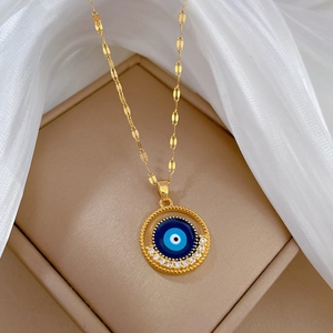 Luxurious gold evil eye necklace with blue pendant and crystals on white silk