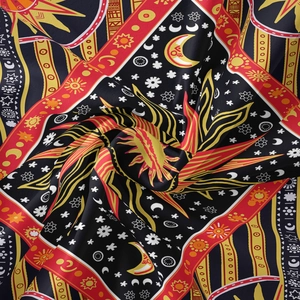 Close-up of bohemian tapestry fabric with celestial sun and moon printed patterns