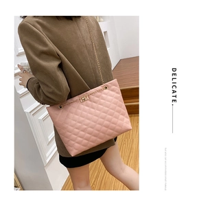 Detailed view of pink quilted leather chain bag with a gold metal turn-lock closure