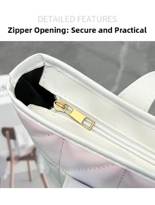 Macro detail of high-quality zipper closure on gradient quilted tote bag with white leather trim