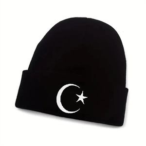 Detail of knit beanie texture with white embroidered moon and star on black cuff