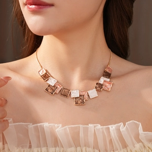Detail of minimalist geometric square oil drop pendant necklace set on model's neck