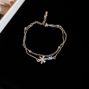 Detail of silver double-layered chain bracelet with zircon flower pendant and lobster clasp