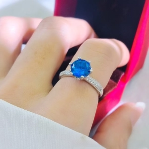 Detail of a 2-carat blue sapphire ring with a six-prong setting on a silver-colored band
