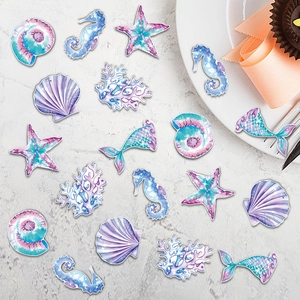 Macro shot of mermaid theme table confetti with seahorses, starfish, and shells