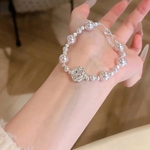 Élégant bracelet en perles avec breloque fleur en zircon argenté au poignet