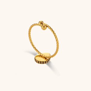 Detail of gold twisted rope ring with oval base and precise black groove carvings
