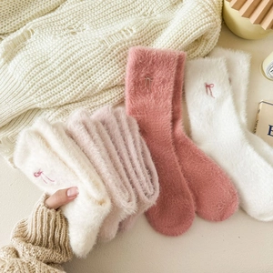 Close-up of soft plush mink velvet socks in pink and white with embroidered bow detail