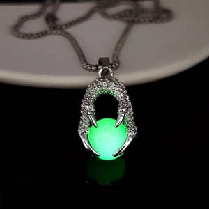 Luminous green dragon claw pendant necklace glowing intensely against a dark background