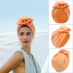 Orange fashion turban for women with large bow design shown in multiple viewing angles