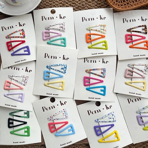 Macro detail of colorful triangle hair clips with various floral and geometric patterns