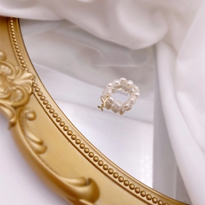 Detailed shot of freshwater pearl ring with gold letter Y pendant on vintage mirror
