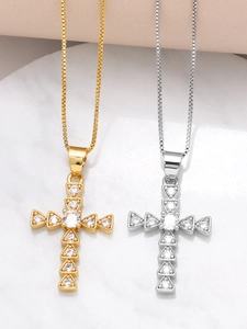 Close-up of gold and silver cross pendants with shimmering cubic zirconia settings
