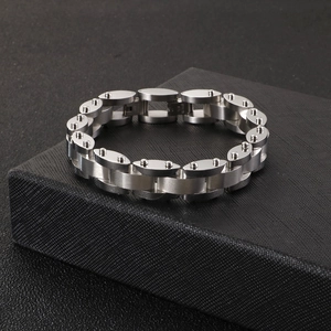 Detail of heavy industrial style stainless steel chain bracelet on a black jewelry box