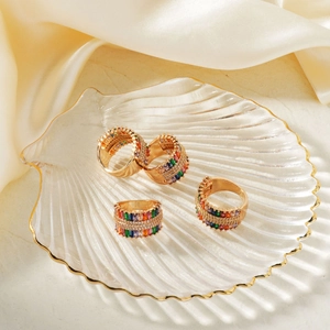 18K gold plated wide rings with rainbow zircon stones on elegant champagne silk background