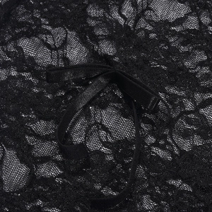 Close-up of black floral lace fabric featuring a delicate satin bow detail on the garment
