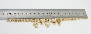 Detail showing gold stainless steel rose bracelet length measured with a metal ruler