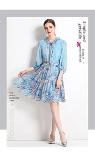 Close-up of light blue floral chiffon dress with ruffled collar and tie-neck detail