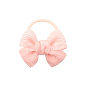Close-up of pink fabric ribbon bow hair tie with a matching elastic band on white background