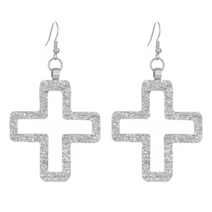 Detail of silver hollow cross earrings featuring hammered texture on white background