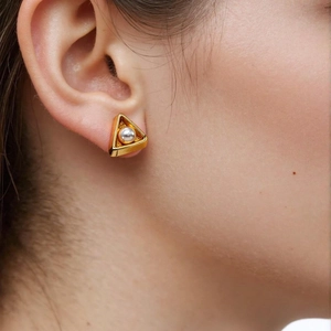 Minimalist 18K gold triangle stud earrings with a pearl center on a female model