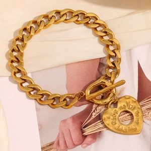Détail du bracelet gourmette plaqué or 18K avec fermoir OT et pendentif cœur