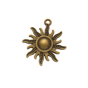 Macro detail of a vintage sun-shaped bronze alloy pendant with textured rays and loop