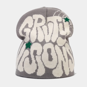 Detail of grey beanie showing white jacquard letters and green star knit pattern