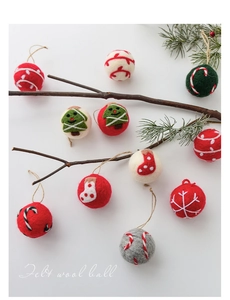 Artistic detail of festive wool felt balls with Christmas patterns on pine branches