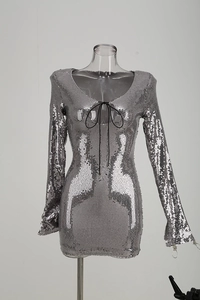 Détail d'une robe argentée à paillettes avec manches longues et lacets noirs au décolleté