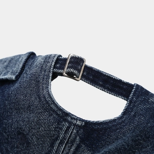 Detailed macro view of the dark blue washed denim texture and adjustable metal buckle