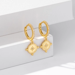 Detail view of gold S925 silver starburst drop earrings with cubic zirconia inlay
