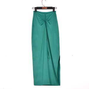 Detail of green ruched maxi skirt featuring an adjustable waist drawstring and side slit
