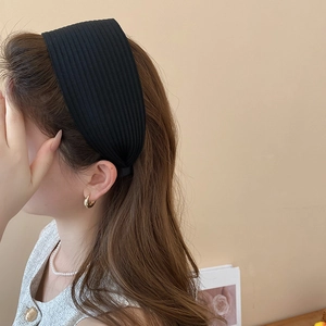 Nahaufnahme des schwarzen gestreiften Stirnbands mit weicher Textur und breitem Design