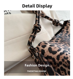 Detail view of leopard print tote bag with knotted shoulder strap and silver rivets