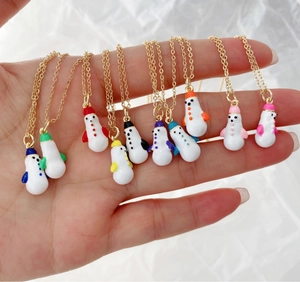 Close-up of assorted snowman pendant necklaces with colorful hats and golden chains