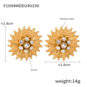 Détail de boucles d'oreilles tournesol en acier titane avec centre en zircon et texture de feuille