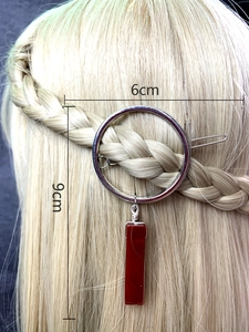 Detailed view of silver circular hair clip with red pendant and 6cm size markings