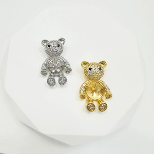 Detail of gold and silver teddy bear pendant settings with cubic zirconia inlay