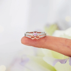 Detail of s925 silver ring with pink heart stone and rose gold infinity symbol design