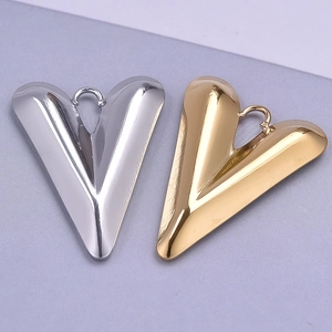 Close-up of heart-shaped stainless steel pendant charms in polished gold and silver finishes