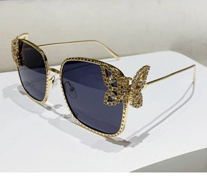 Detailed side view of golden butterfly sunglasses with sparkling crystal embellishments