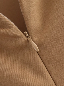 Makroaufnahme von kamelfarbenem Strickstoff mit nahtlosem Reißverschlussdetail