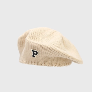 Close-up of beige knit beret with ribbed edge and varsity style letter P patch