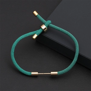 Detail view of emerald green braided rope bracelet with adjustable gold slider beads