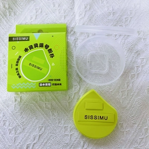 Macro shot of green teardrop makeup sponge with brand strap and clear storage case