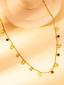 Detail of gold dolphin necklace with colorful zircon stones and fine O-chain links