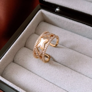 Close-up of a gold star ring with mother of pearl and zircon on black velvet